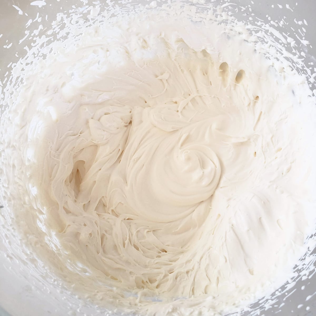 Cheesecake filling whipped in the glass bowl