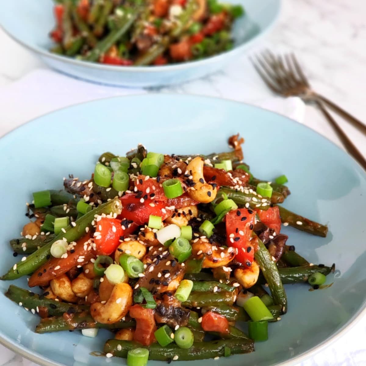 2 light blue bowls of Ginger Vegetable Stir Fry with 2 forks on the right on ShockinglyDelicious.com