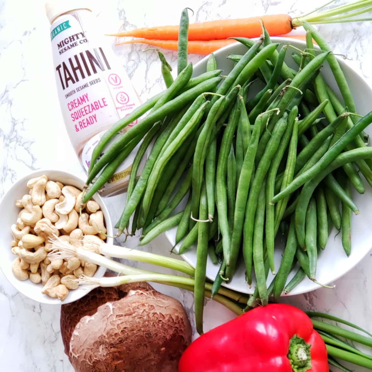 Ingredients for Ginger Vegetable Stir-Fry grouped on a white marble counter on ShockinglyDelicious.com