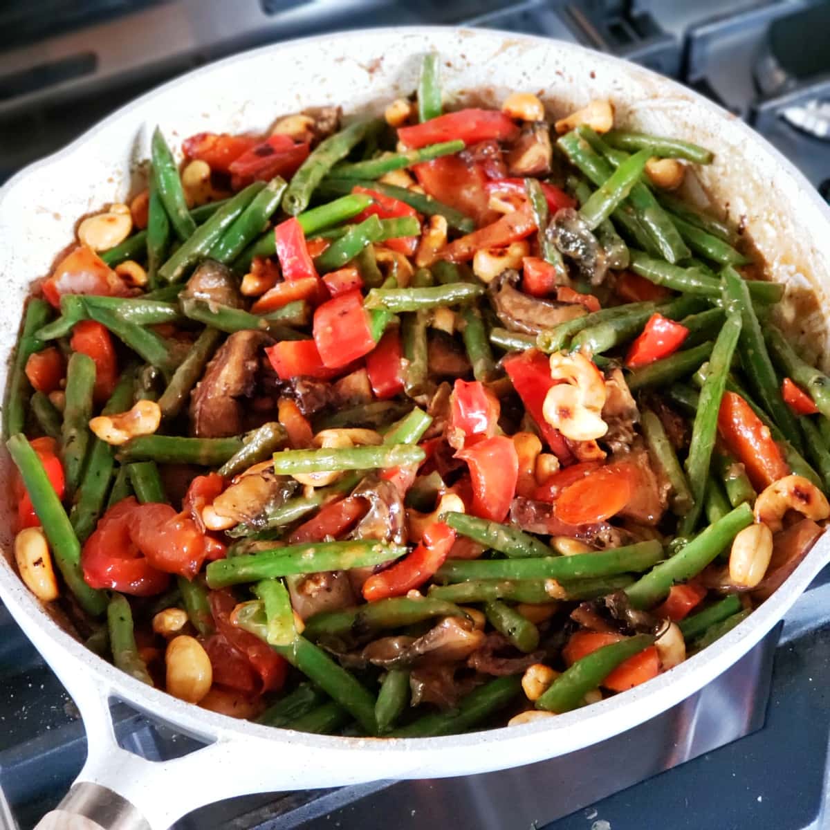 Tahini and sesame sauce coats the colorful vegetables in the skillet on ShockinglyDelicious.com