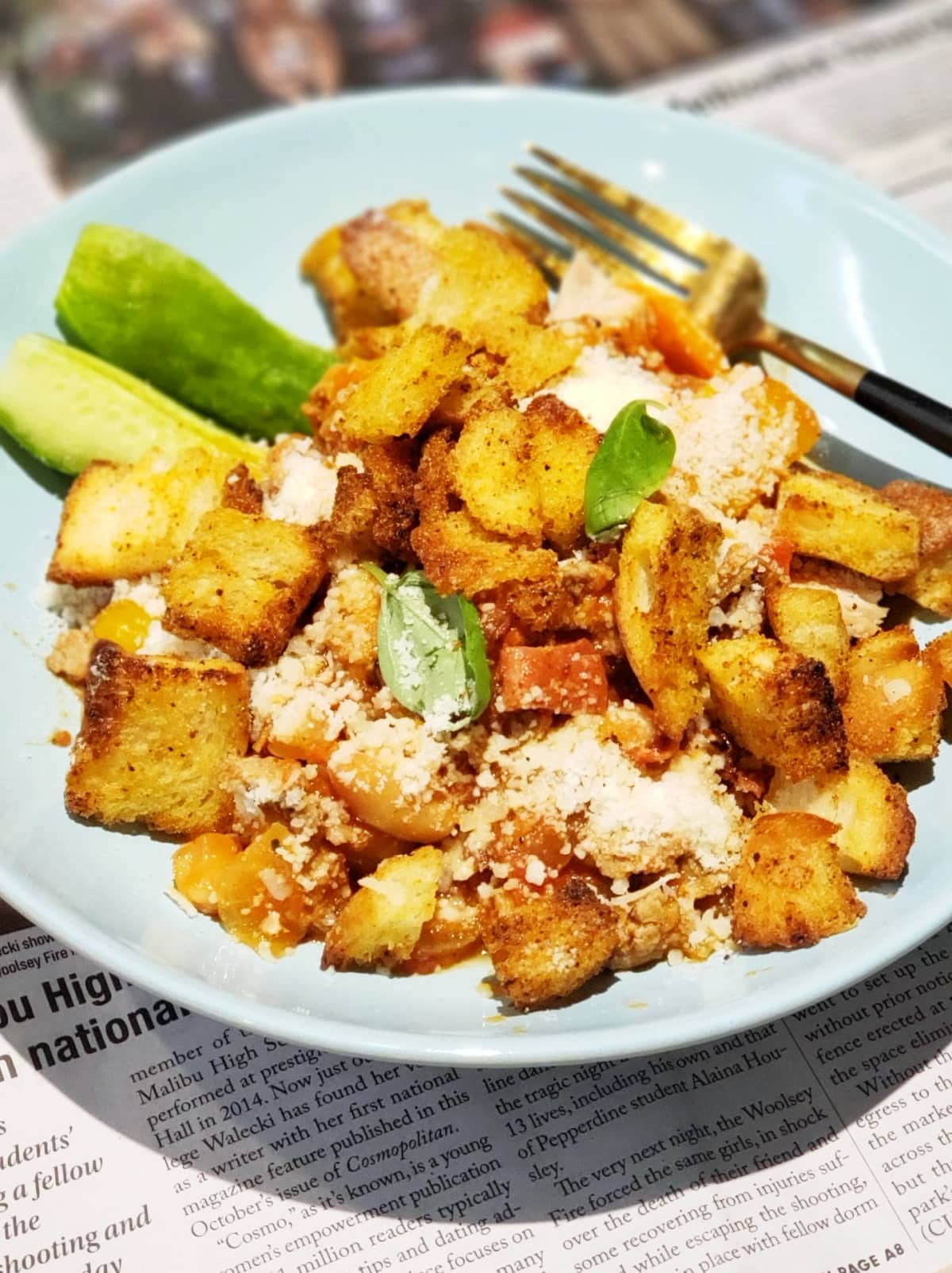 Pizza Chili in an aqua bowl wth croutons on top, sitting on top of a newspaper