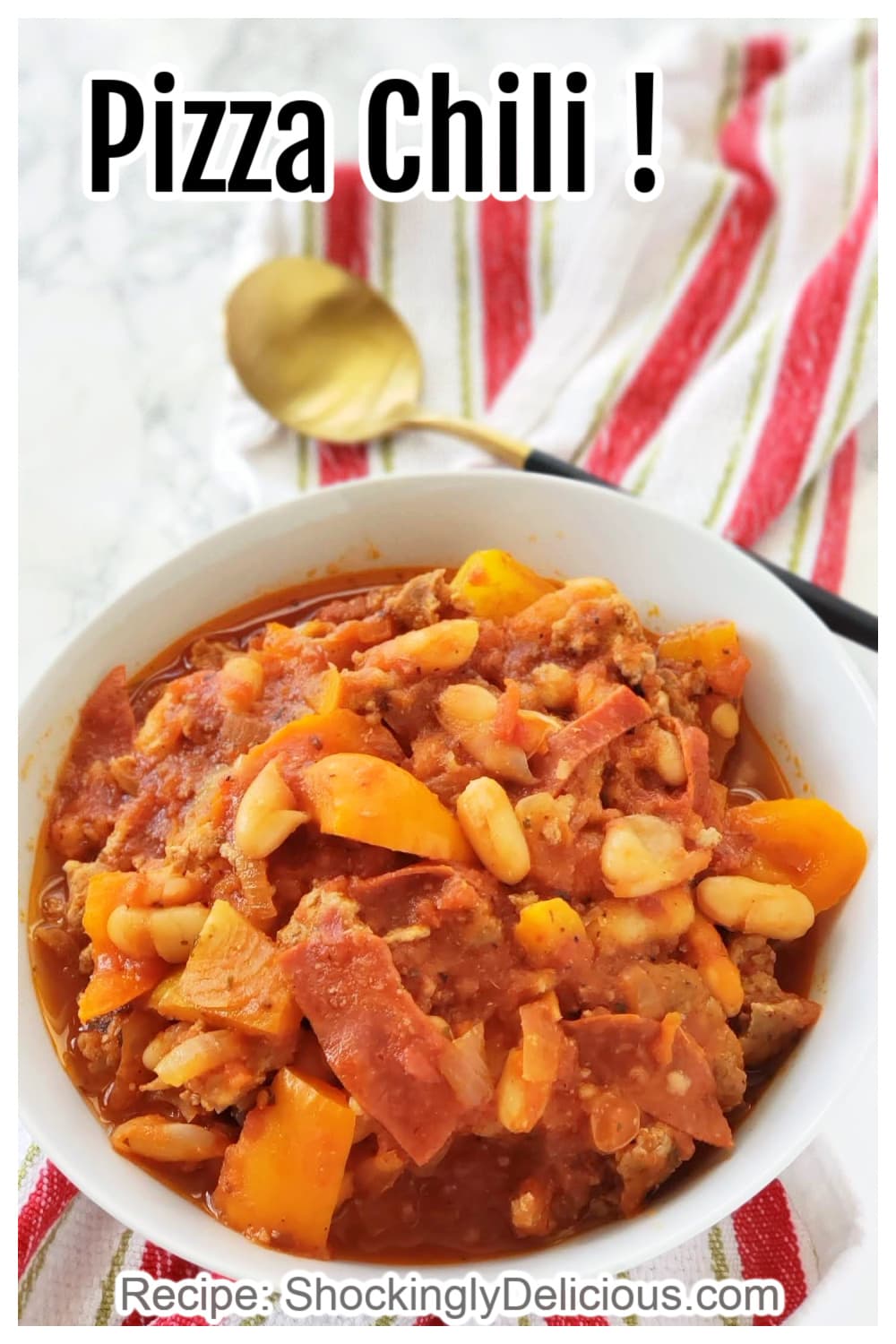 Pizza Chili is for everyone who can't decide between the two -- it's a delicious bowl of pizza flavors in the form of chili, with sausage, pepperoni, beans and tomatoes. Make it in a skillet for a 1-pan meal! White bowl of Pizza Chili with a gold spoon resting on an Italian flag colored towel on a white counter