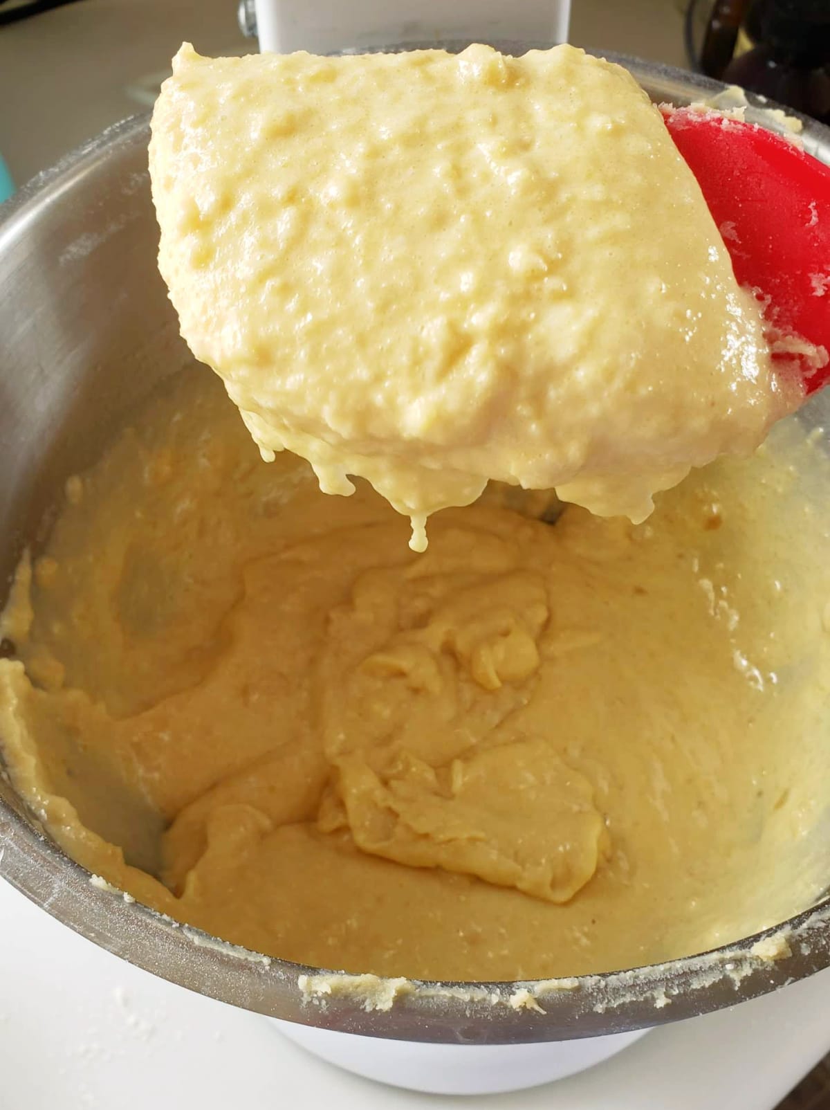 Red spatula holding Almond paste filling after mixing