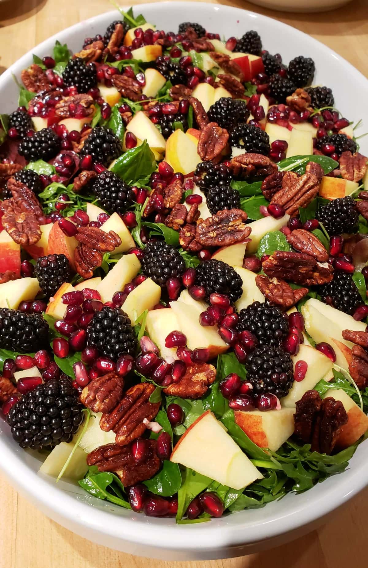 Christmas spinach salad with fruit and Maple Glazed Pecans on top