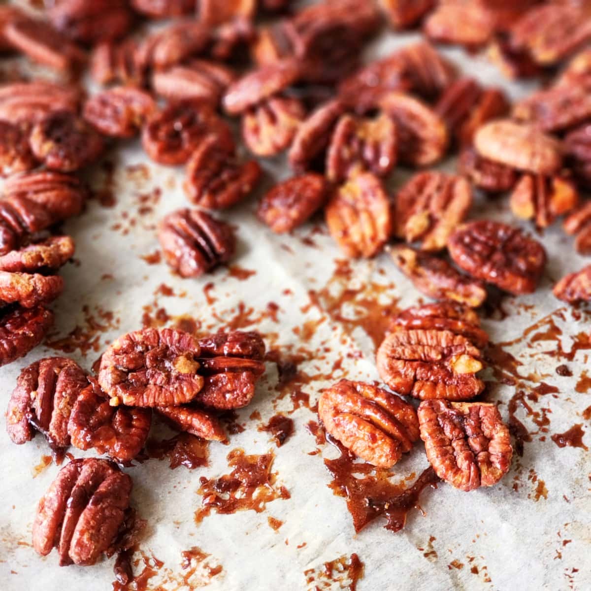 Maple Glazed Pecans on ShockinglyDelicious.com Maple Glazed Pecans on white parchment paper