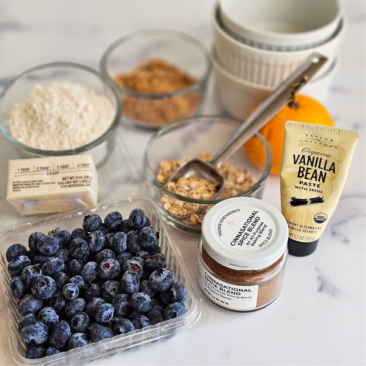 Ingredients for Air Fryer Blueberry Crisp arrayed on a white marble counter