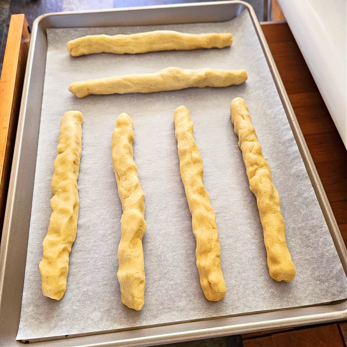 6 logs of dough on a parchment paper-lined baking sheet