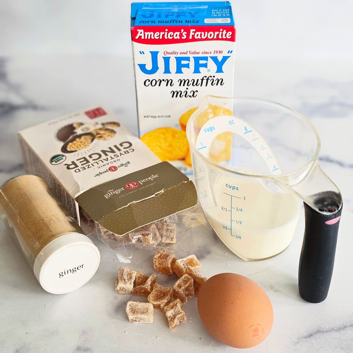 Ingredients for Candied Ginger Cornbread on a white marble countertop